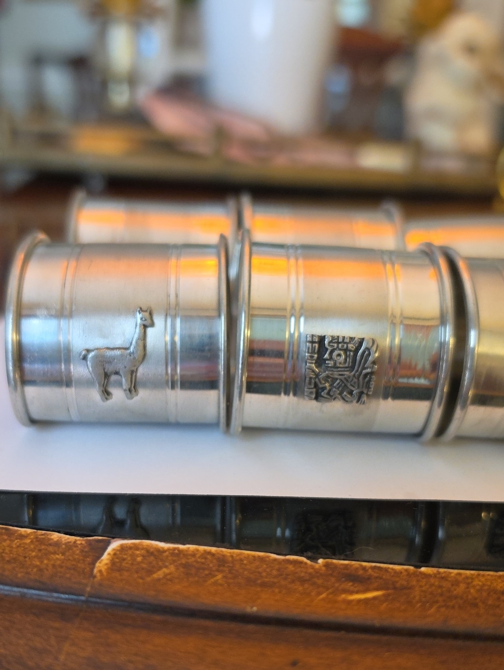 Vintage silver-tone metal napkin rings featuring embossed animal and crest motif